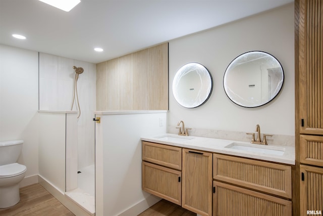 bathroom featuring hardwood / wood-style flooring, toilet, walk in shower, and vanity