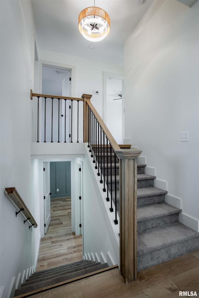 stairs with ceiling fan and hardwood / wood-style flooring