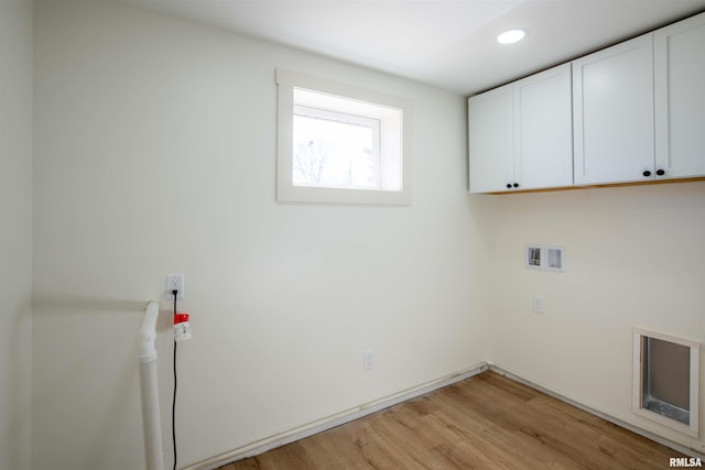 laundry area with cabinets, light hardwood / wood-style floors, and hookup for a washing machine