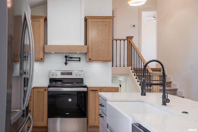 kitchen with ceiling fan, backsplash, sink, stainless steel appliances, and light stone counters