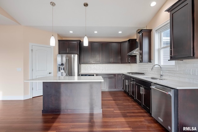 kitchen with sink, a center island, hanging light fixtures, tasteful backsplash, and appliances with stainless steel finishes