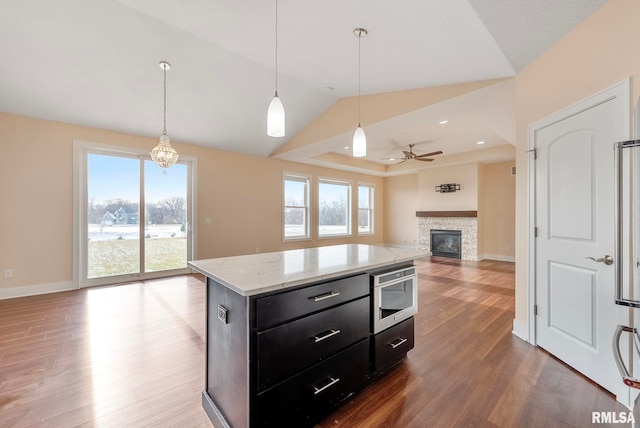 kitchen with pendant lighting, a kitchen island, ceiling fan, and wood-type flooring