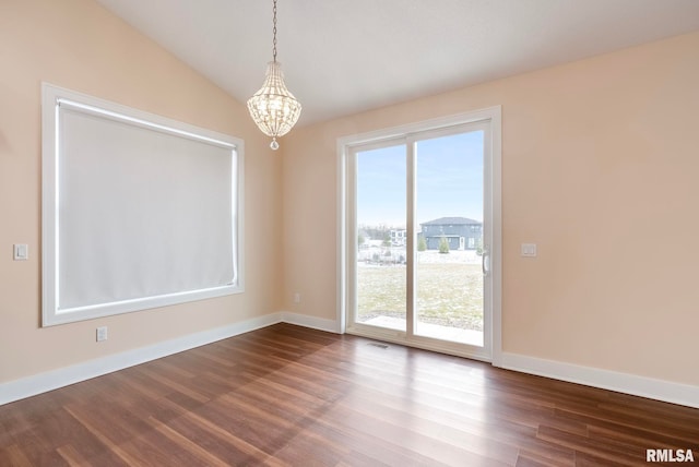 unfurnished dining area with hardwood / wood-style floors, vaulted ceiling, and an inviting chandelier