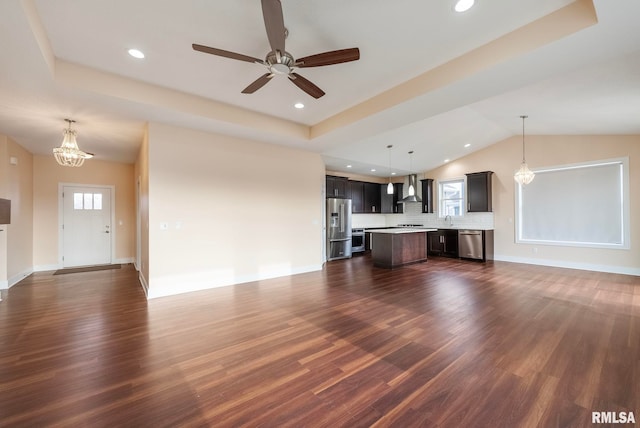 unfurnished living room with ceiling fan with notable chandelier, dark hardwood / wood-style floors, lofted ceiling, and sink