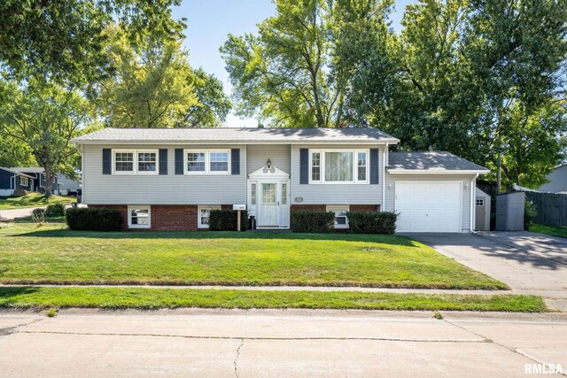 raised ranch featuring a front lawn and a garage