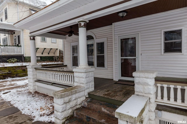 snow covered deck with ceiling fan and a porch