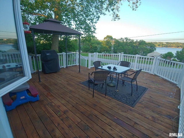 wooden terrace with a water view and area for grilling