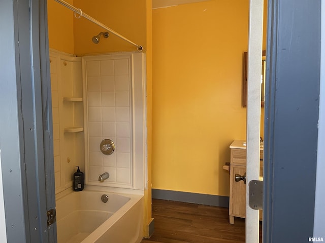 bathroom with hardwood / wood-style flooring and bathing tub / shower combination