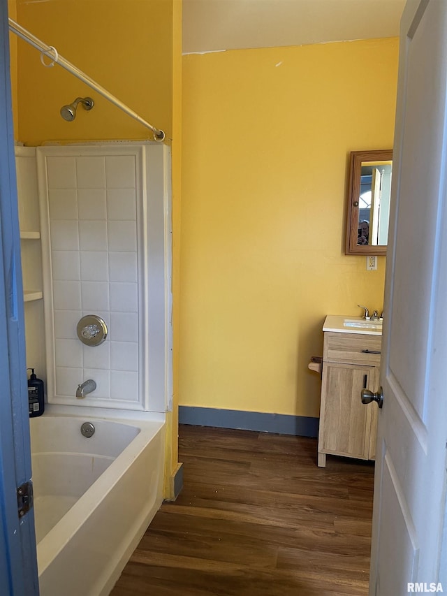 bathroom featuring washtub / shower combination, hardwood / wood-style flooring, and vanity