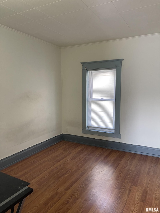 unfurnished room with dark hardwood / wood-style floors and crown molding