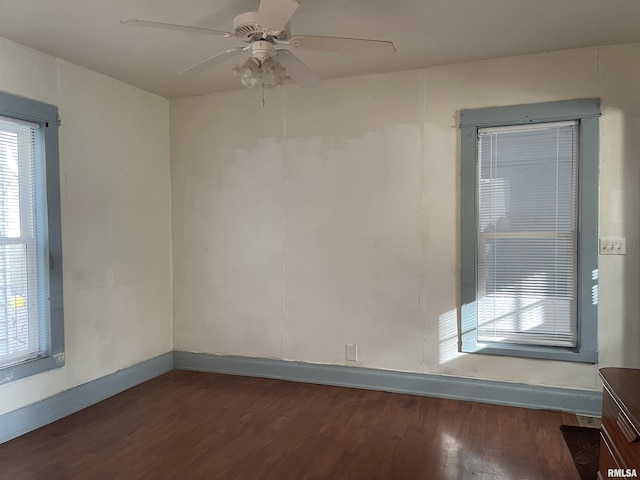 spare room featuring ceiling fan, a wealth of natural light, and dark hardwood / wood-style floors