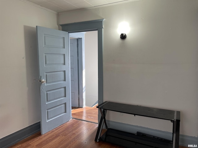 hallway with ornamental molding and hardwood / wood-style flooring