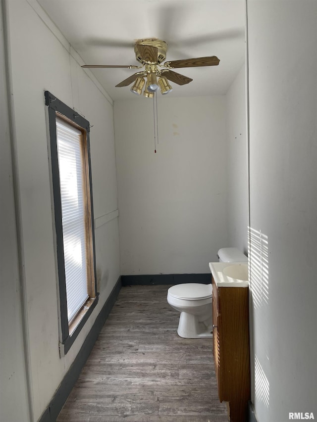 bathroom with ceiling fan, vanity, wood-type flooring, and toilet