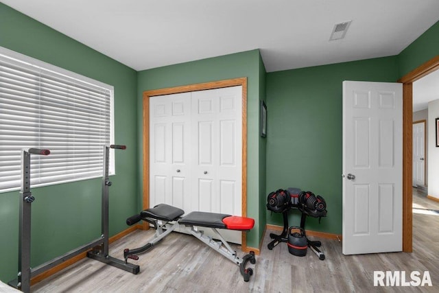 workout area with light hardwood / wood-style flooring