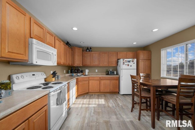 kitchen with light hardwood / wood-style floors and white appliances