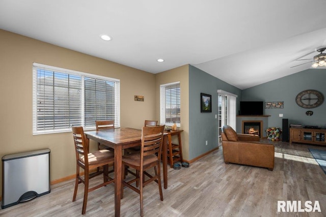 dining room featuring light hardwood / wood-style floors, ceiling fan, and lofted ceiling