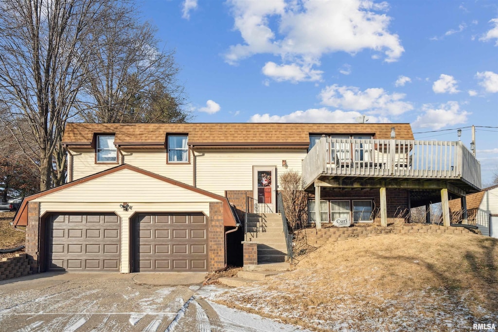 view of front of house with a garage, driveway, and a shingled roof