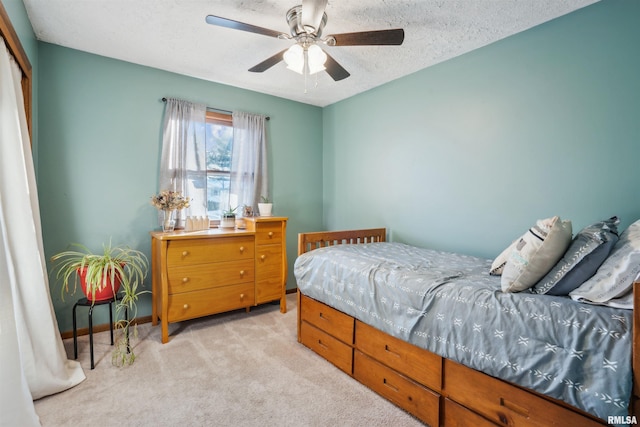 carpeted bedroom with a textured ceiling, ceiling fan, and a closet