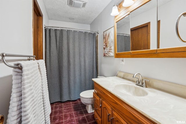 bathroom with a textured ceiling, vanity, and toilet