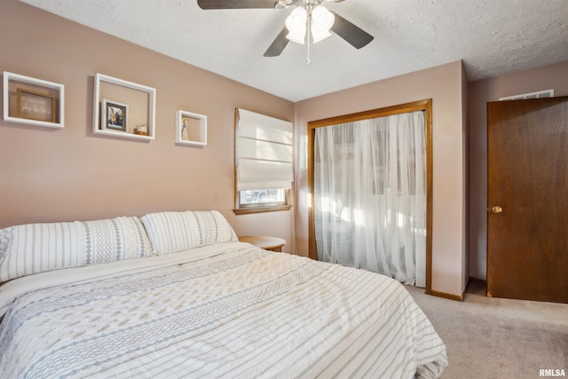 bedroom featuring light carpet, ceiling fan, and a textured ceiling