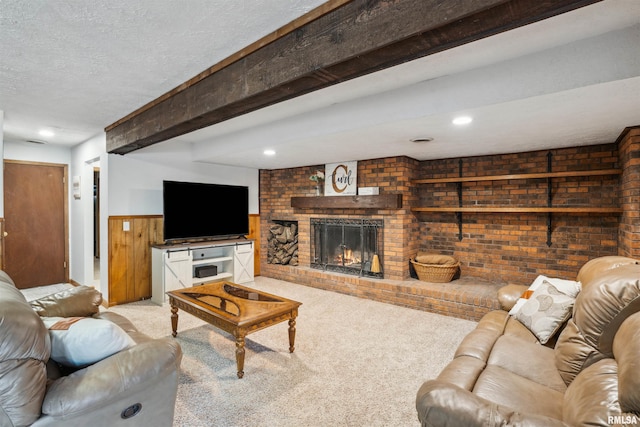 carpeted living room with wooden walls, a textured ceiling, a brick fireplace, and beam ceiling