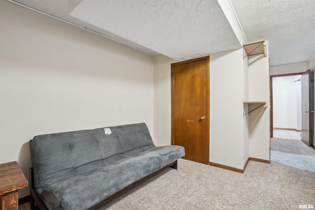 sitting room featuring a textured ceiling and light carpet