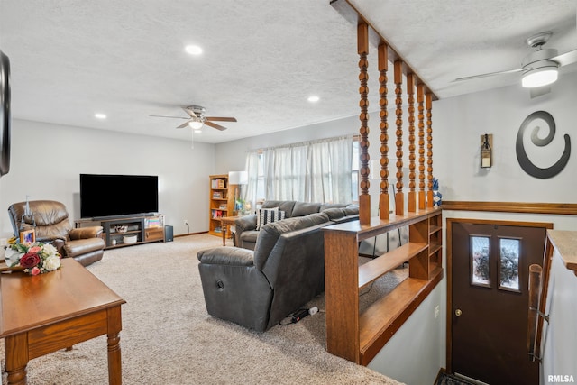 living room featuring a textured ceiling, ceiling fan, and carpet