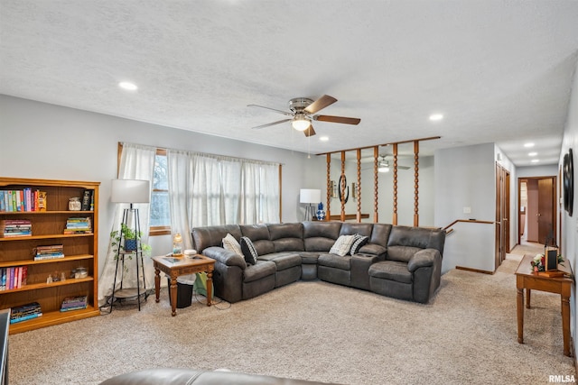 living room featuring a textured ceiling, ceiling fan, and light colored carpet