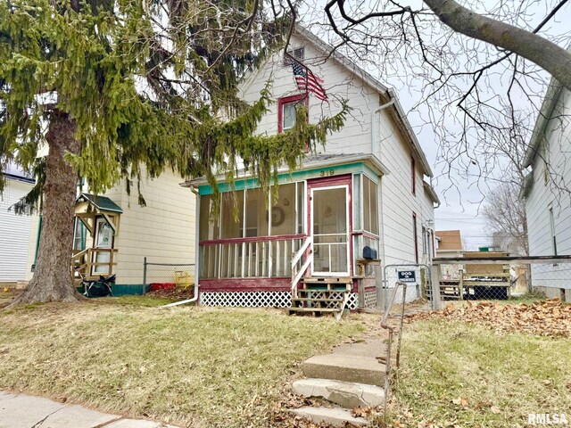 view of front of home with a front yard and a sunroom