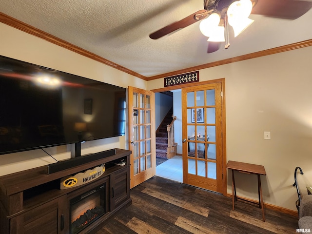 living room featuring french doors, hardwood / wood-style flooring, ceiling fan, ornamental molding, and a textured ceiling