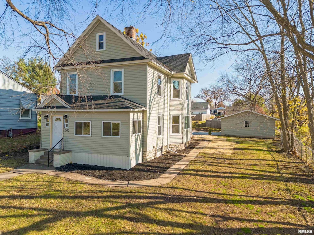 rear view of house featuring a lawn, entry steps, and a chimney