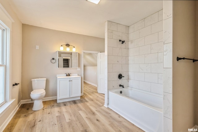 full bathroom with vanity, toilet, wood-type flooring, and tiled shower / bath combo