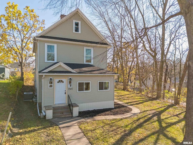 view of property featuring a front yard and central AC