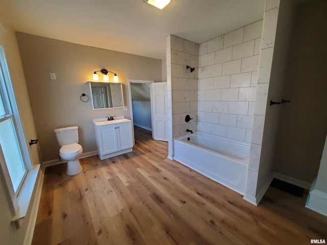 full bathroom with shower / bathing tub combination, vanity, hardwood / wood-style flooring, and toilet