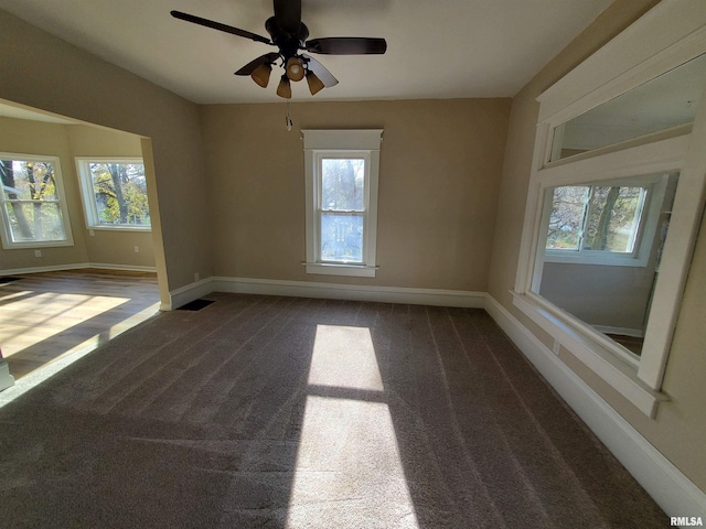 carpeted spare room featuring ceiling fan