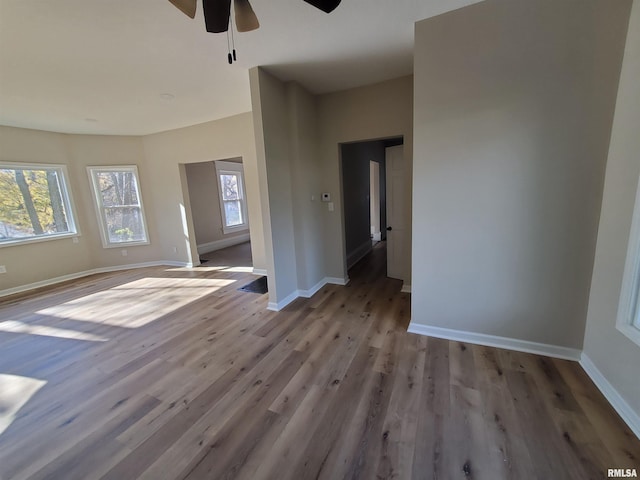 unfurnished room with ceiling fan, a healthy amount of sunlight, and light wood-type flooring