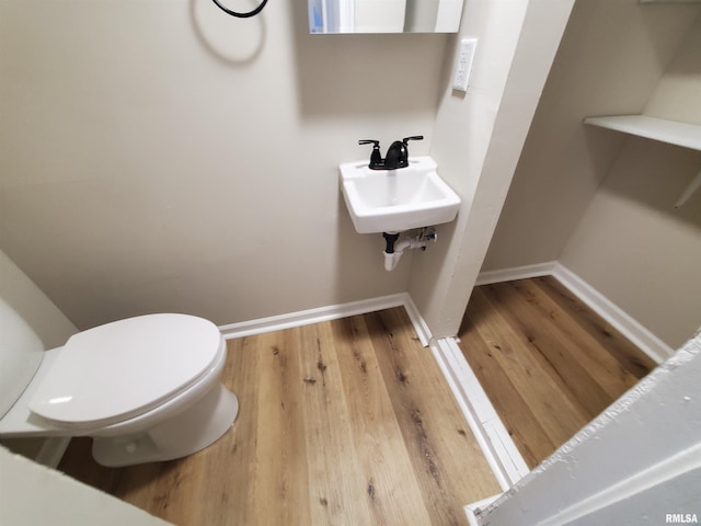 bathroom with sink, hardwood / wood-style floors, and toilet