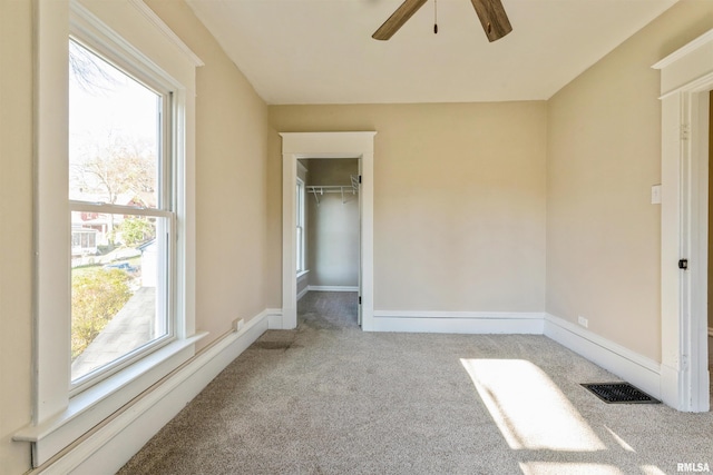 unfurnished bedroom featuring ceiling fan, a closet, and light carpet