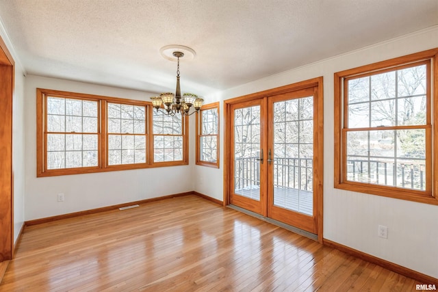 interior space featuring light hardwood / wood-style flooring, a chandelier, and french doors