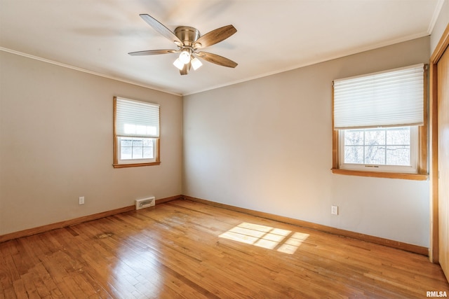 empty room featuring ceiling fan, light wood-type flooring, and ornamental molding