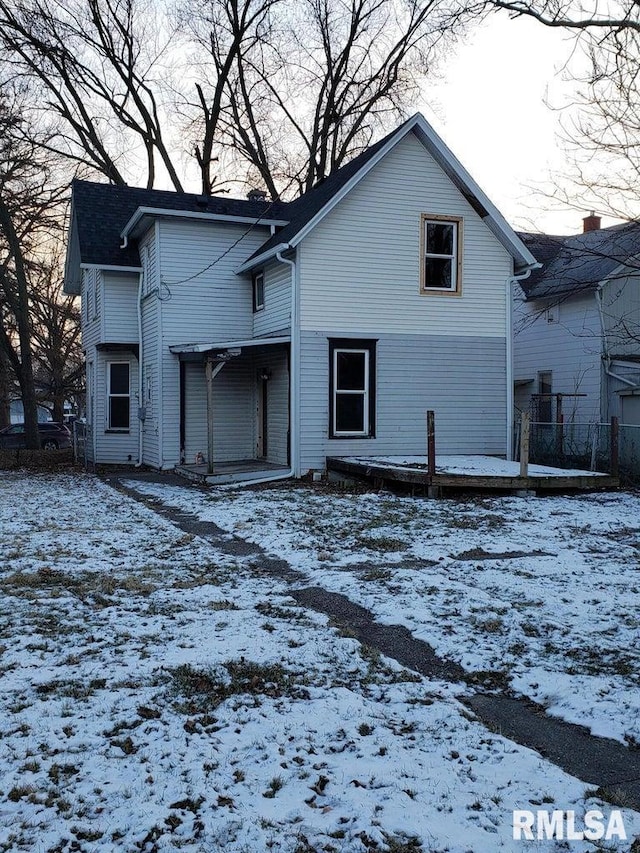 view of snow covered back of property