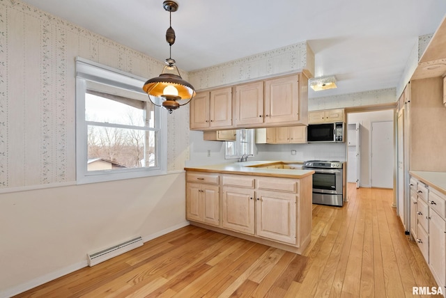 kitchen featuring hanging light fixtures, light wood-type flooring, stainless steel range oven, and a baseboard radiator