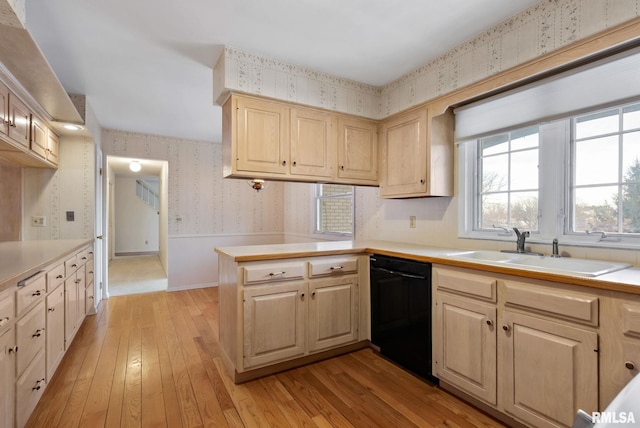 kitchen with dishwasher, kitchen peninsula, sink, light wood-type flooring, and light brown cabinetry