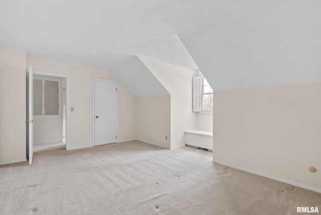 additional living space featuring light carpet and lofted ceiling