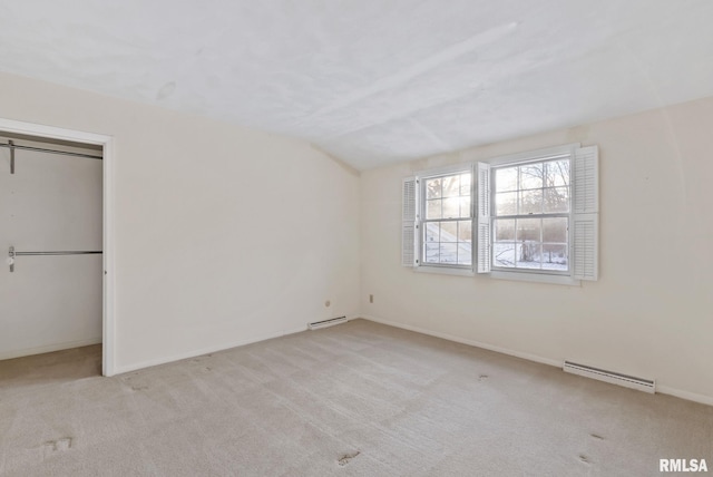 unfurnished bedroom with a closet, lofted ceiling, light colored carpet, and baseboard heating