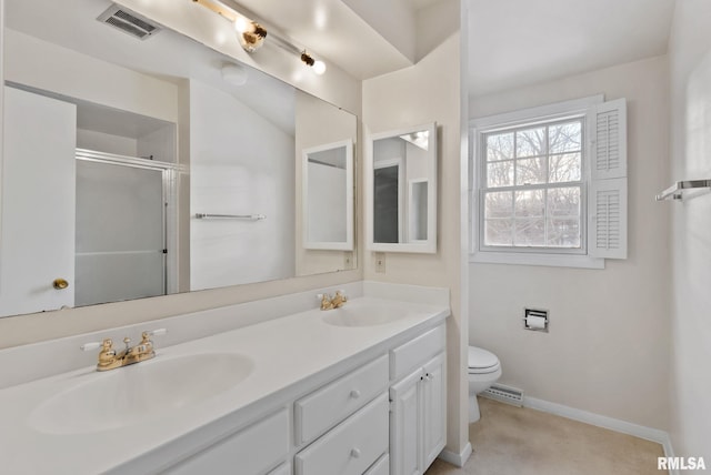 bathroom featuring toilet, a shower with shower door, and vanity