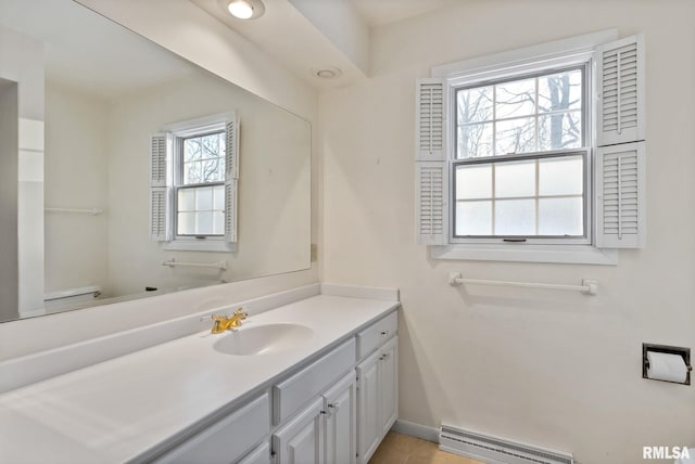 bathroom with toilet, baseboard heating, and vanity