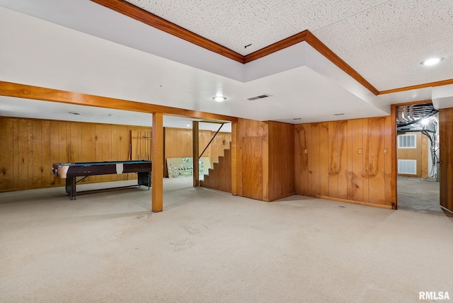 basement with light carpet, crown molding, wood walls, and billiards