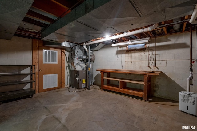 basement with heating unit and a workshop area