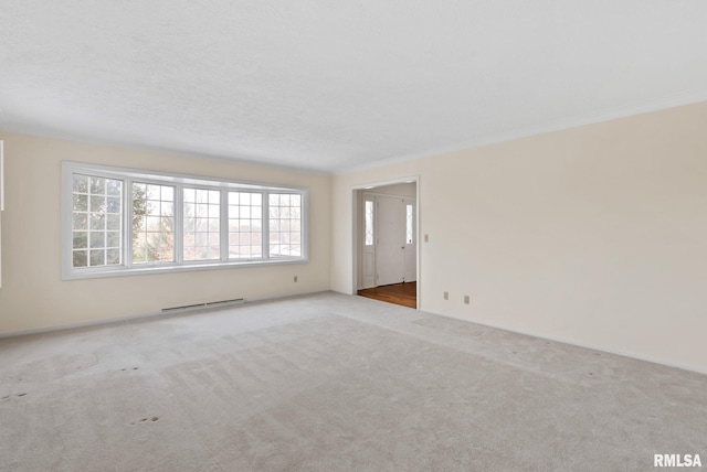 carpeted empty room with a baseboard radiator and ornamental molding